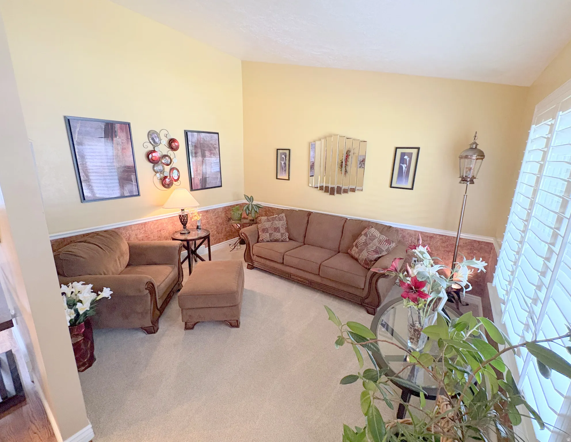 Carpeted interior space featuring light yellow walls and a decorative chair rail with patterned wallpaper
