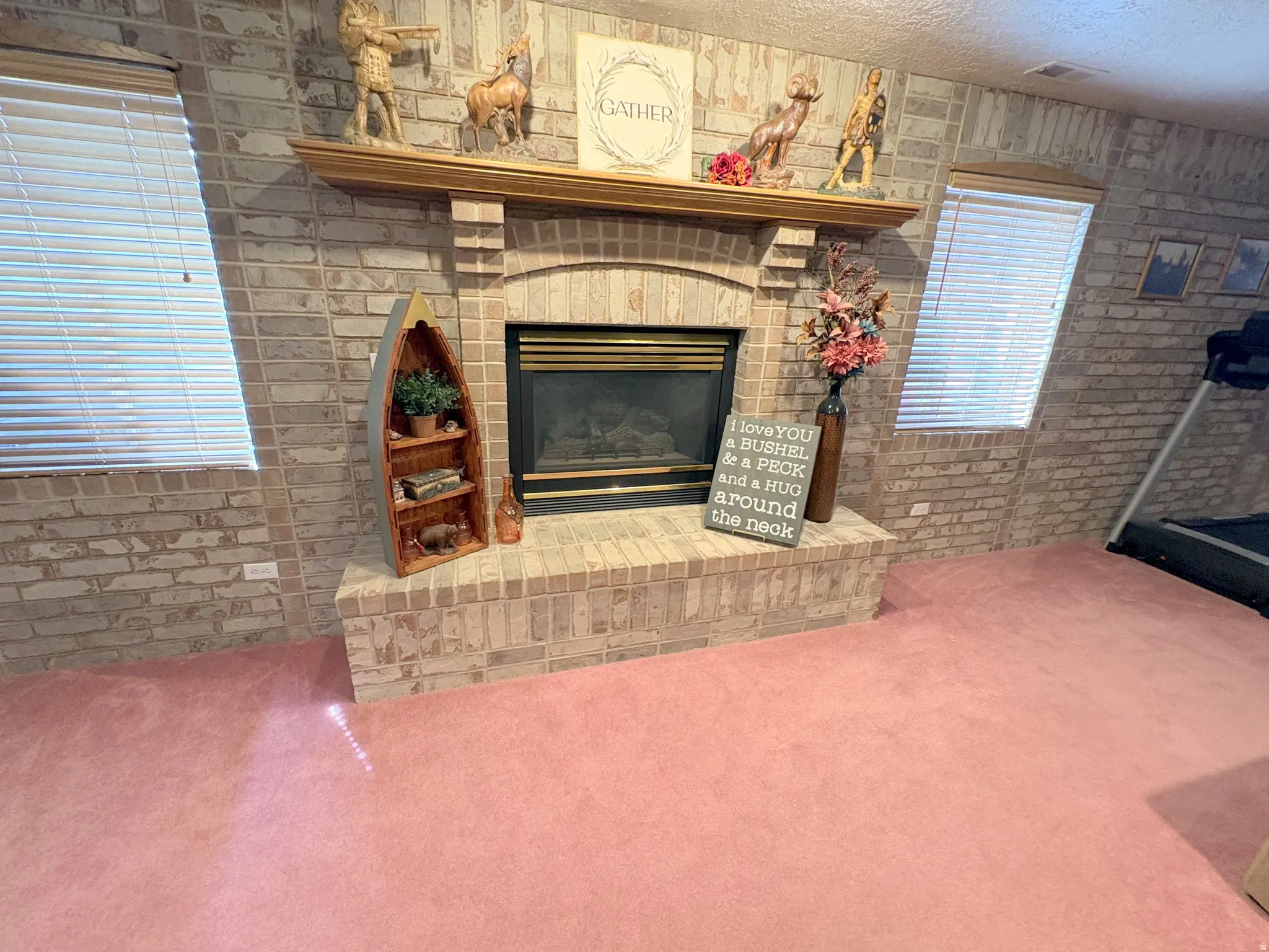 Brick-clad fireplace featuring a wood mantel