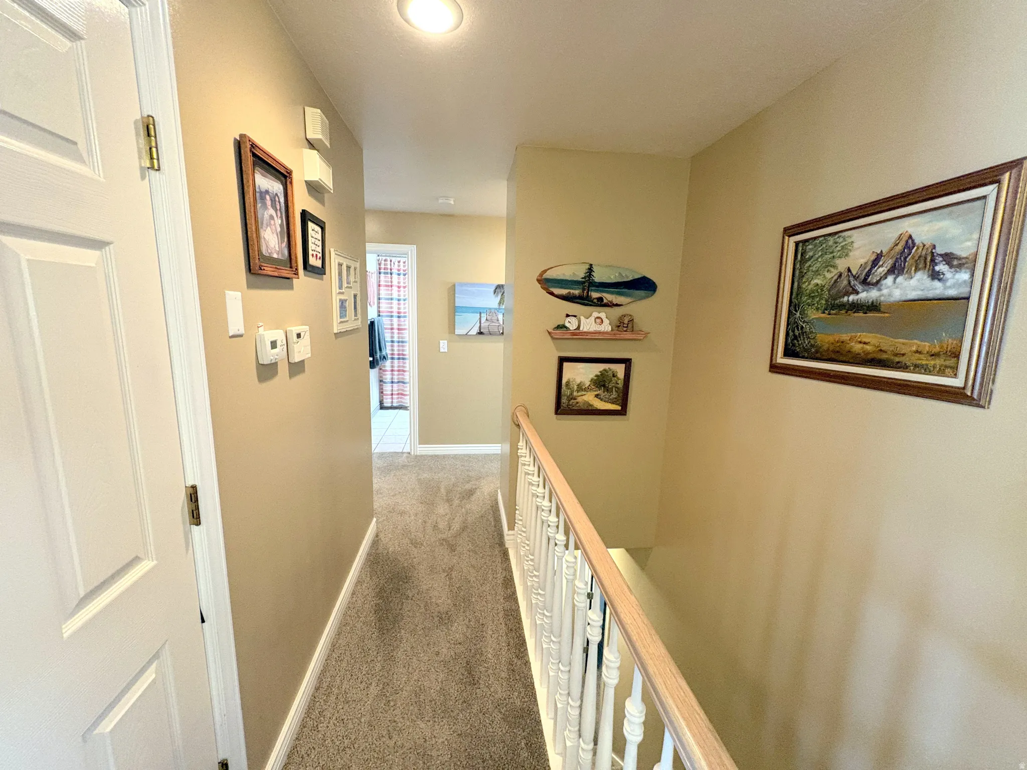 Upper-level hallway featuring neutral wall tones, recessed lighting, and carpet flooring