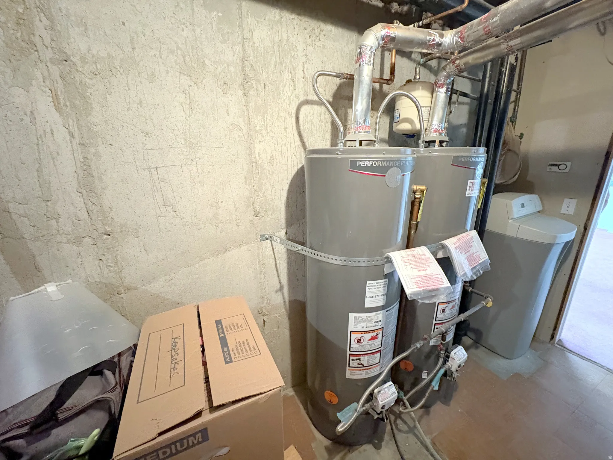 Utility area featuring two large water heaters and a water softener system