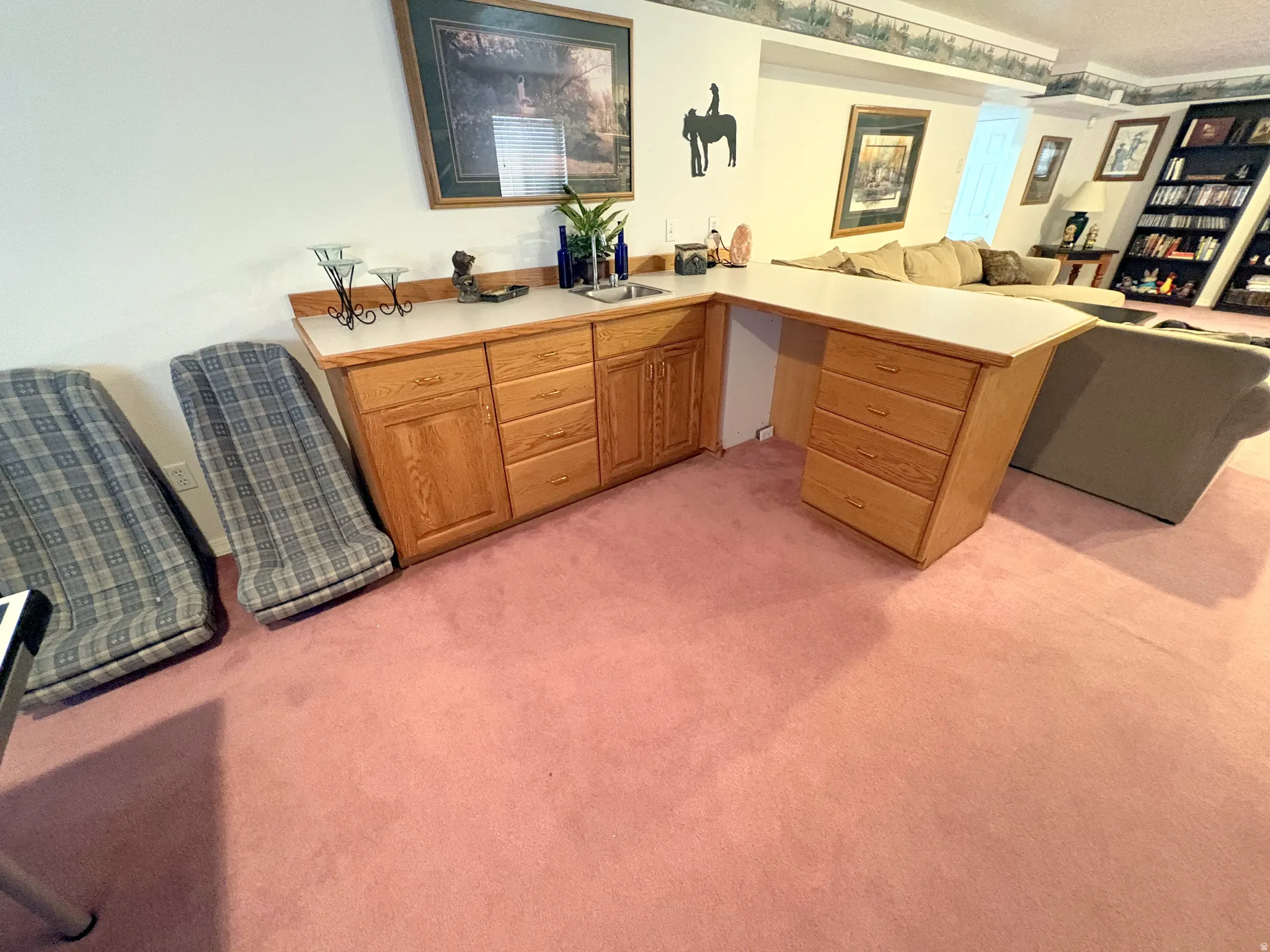 Built-in wood-finish cabinetry featuring a sink, countertop, and ample storage