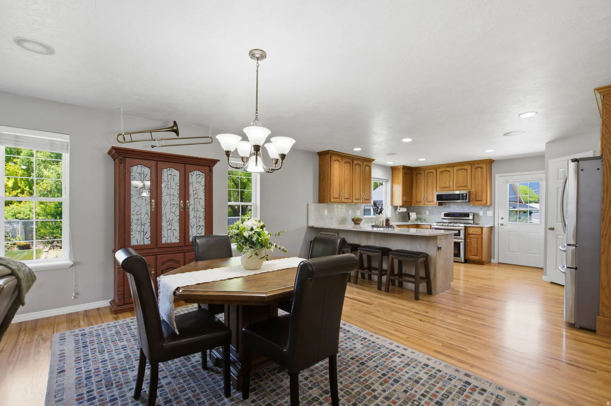 Open-concept dining and kitchen area featuring wood-finish flooring