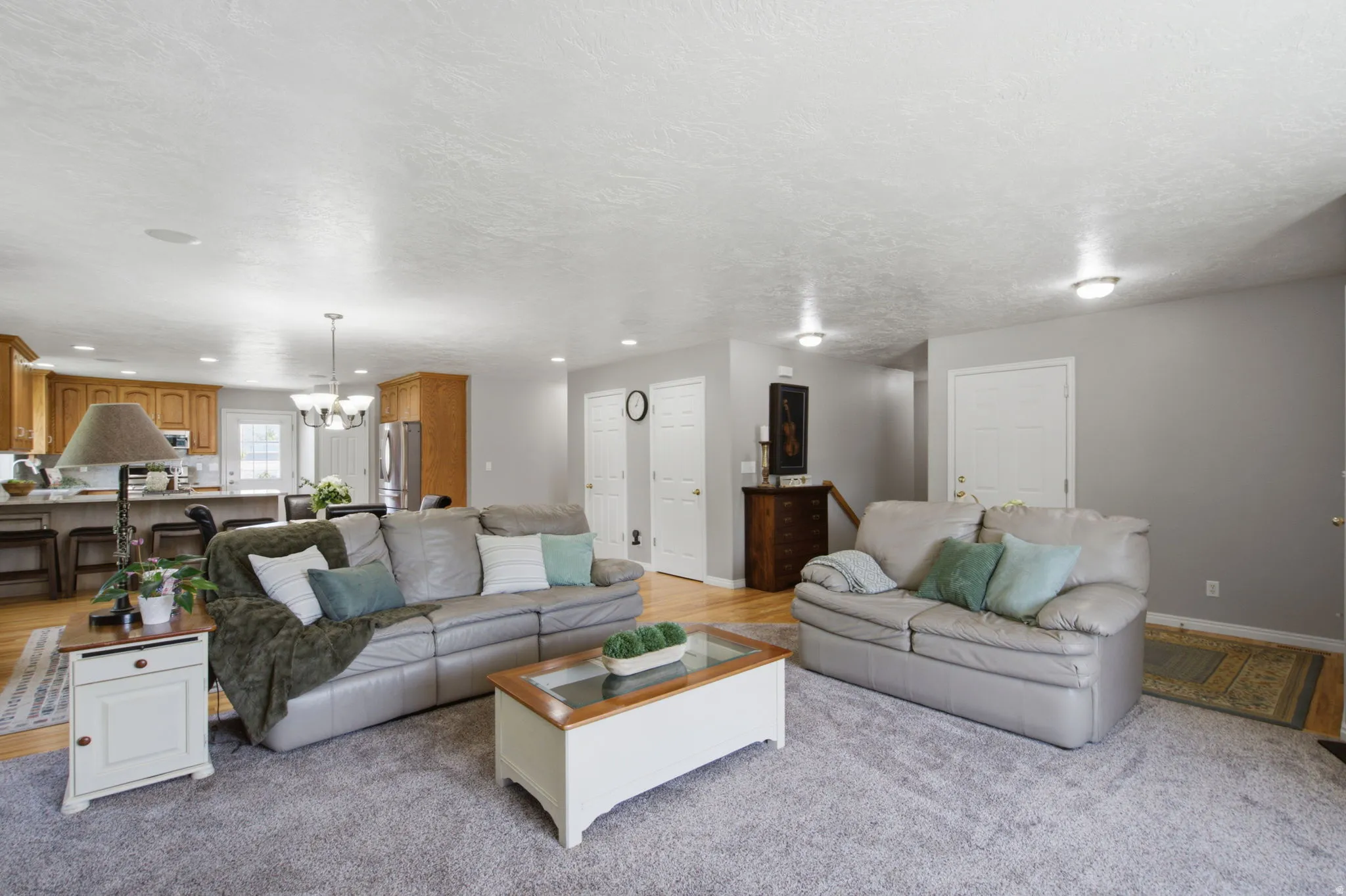 Spacious living area featuring light gray wall paint, recessed lighting, and a neutral carpet