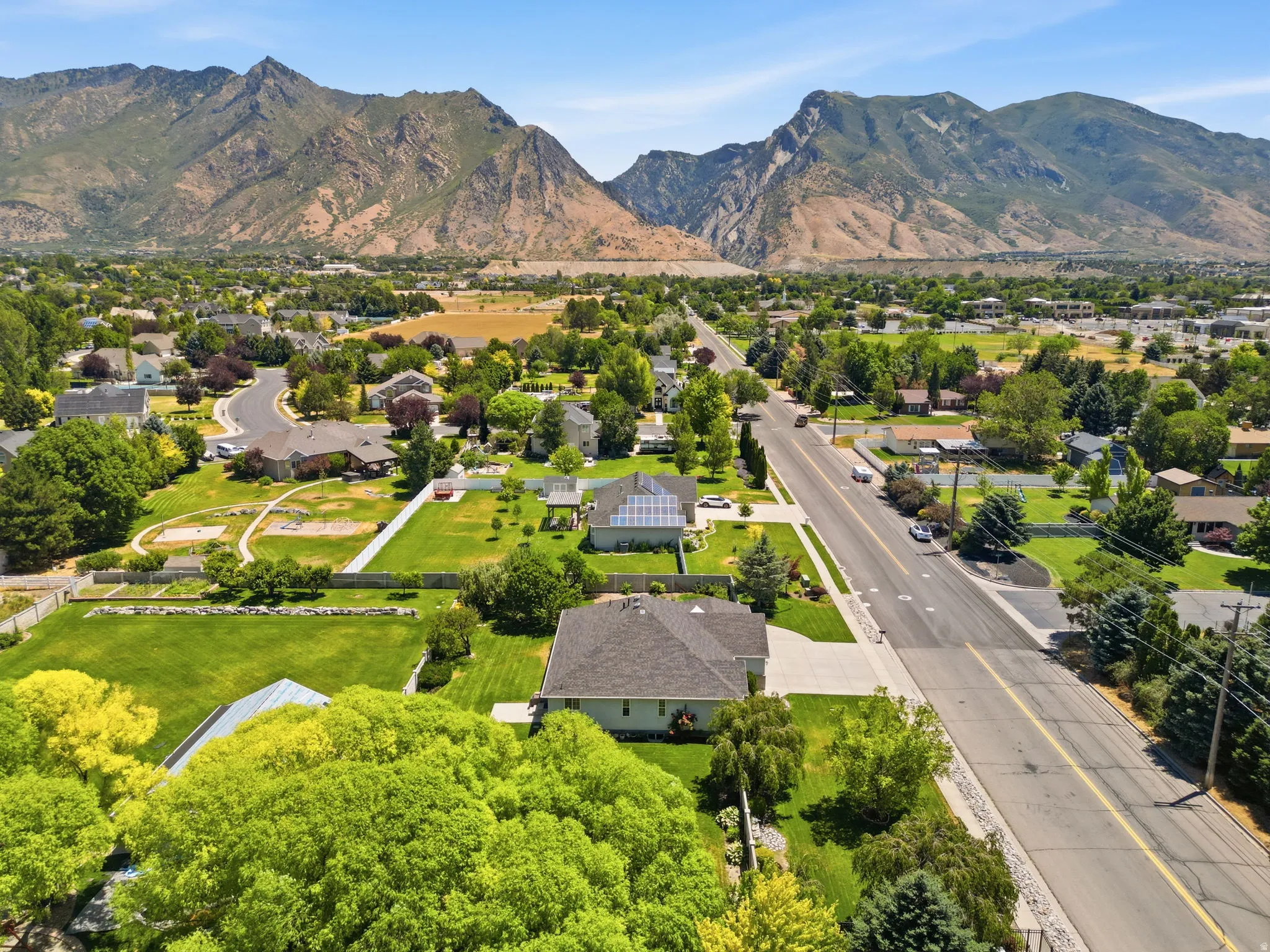 Expansive mountain range backdrop with residential homes and mature trees
