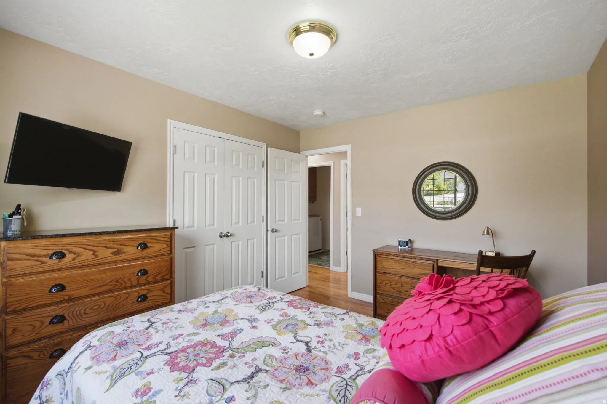 Bedroom featuring two closet doors with white paneling and brushed nickel hardware