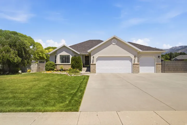 Stucco exterior residence featuring a two-car garage, a single-car garage, and a concrete driveway