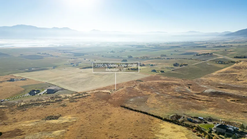 Expansive rural landscape featuring rolling hills and distant mountains