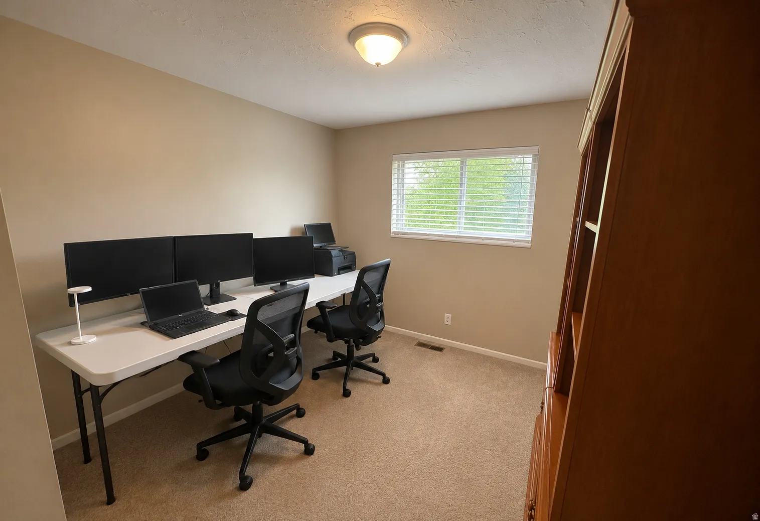 Neutral-toned walls complement the carpet flooring