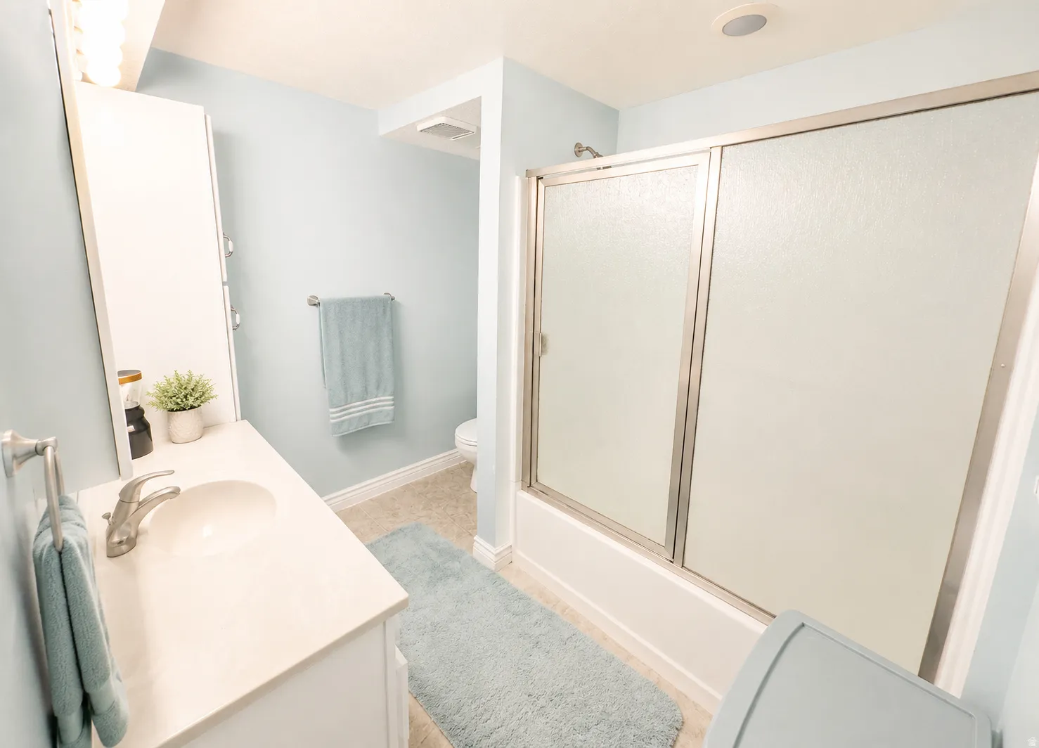 Bathroom featuring a white vanity with a single basin sink, brushed nickel faucet, and a wall-mounted medicine cabinet