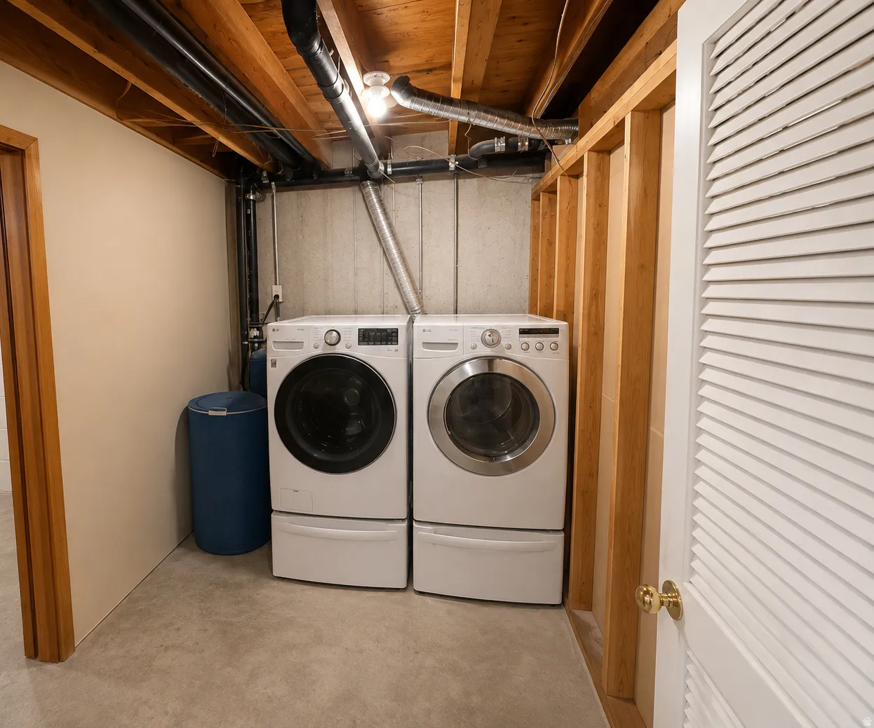 Dedicated laundry area featuring front-loading washer and dryer units with pedestal bases