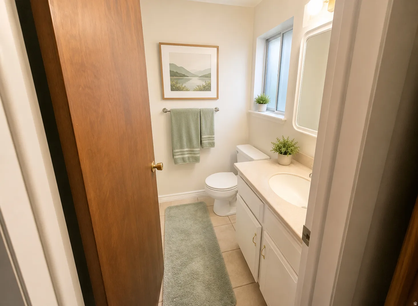 Bathroom featuring a single vanity with built-in cabinetry, an integrated sink, and a framed mirror