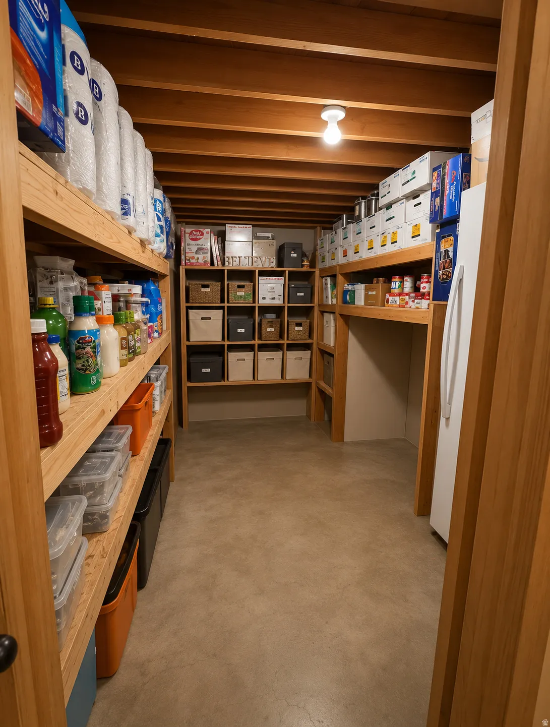 Dedicated storage area featuring exposed wood ceiling joists and concrete flooring