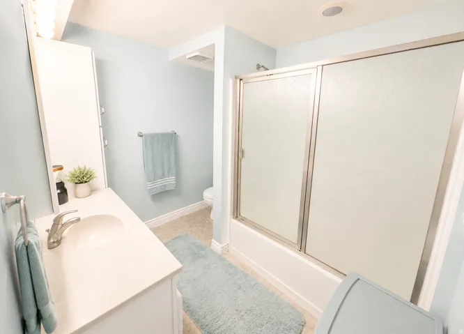 Bathroom featuring a white vanity with a single basin sink, brushed nickel faucet, and a wall-mounted medicine cabinet