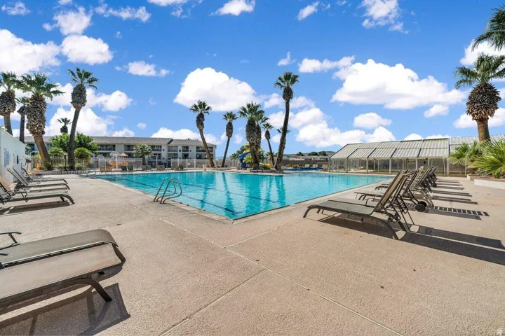 Expansive communal swimming pool surrounded by a concrete deck