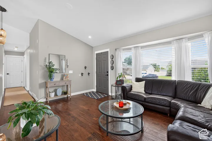 Spacious living area featuring rich wood-finish flooring and a bright bay window