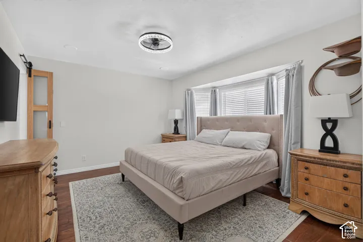 Room featuring wood-finish flooring, a contemporary ceiling fan, and a light gray color palette