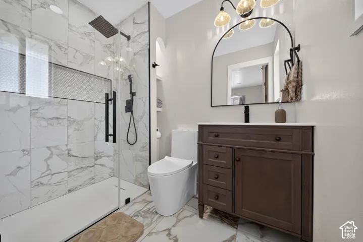 Shower with glass enclosure, rain shower head, and wall-mounted shower system