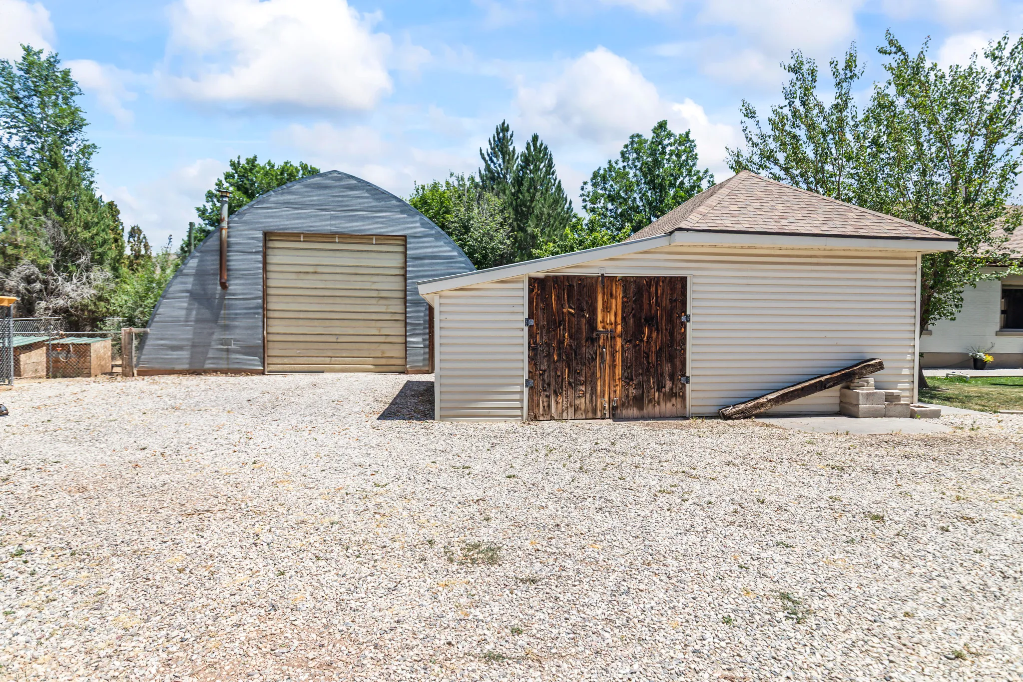 Gravel driveway with two outbuildings