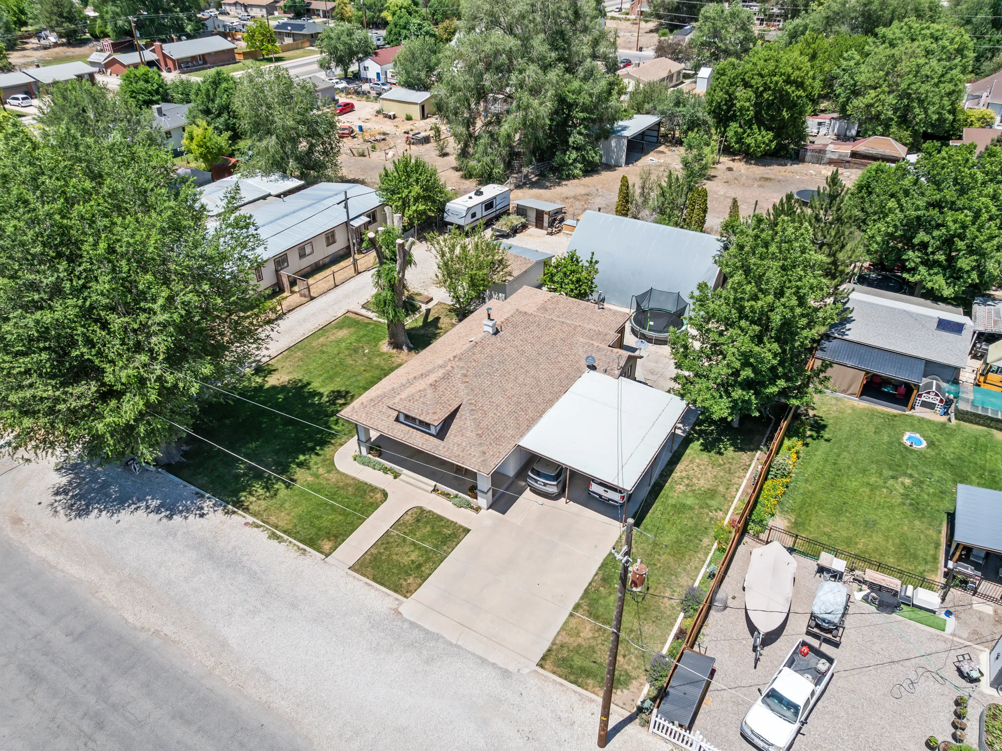 Single-story residence featuring a brown shingle roof, attached carport, and a paved driveway