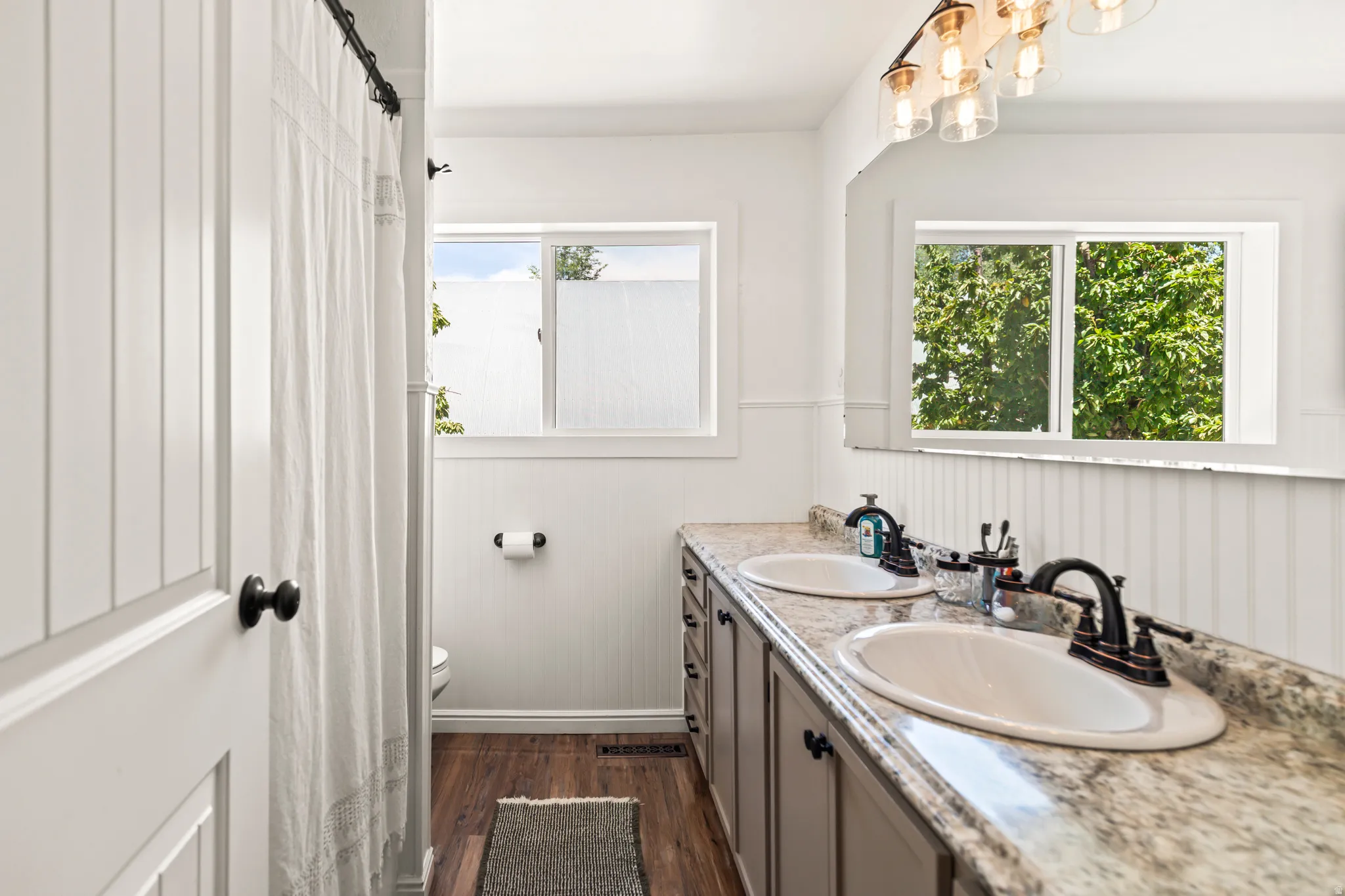 Dual vanity with integrated sinks, granite-finish countertop, and dark bronze fixtures