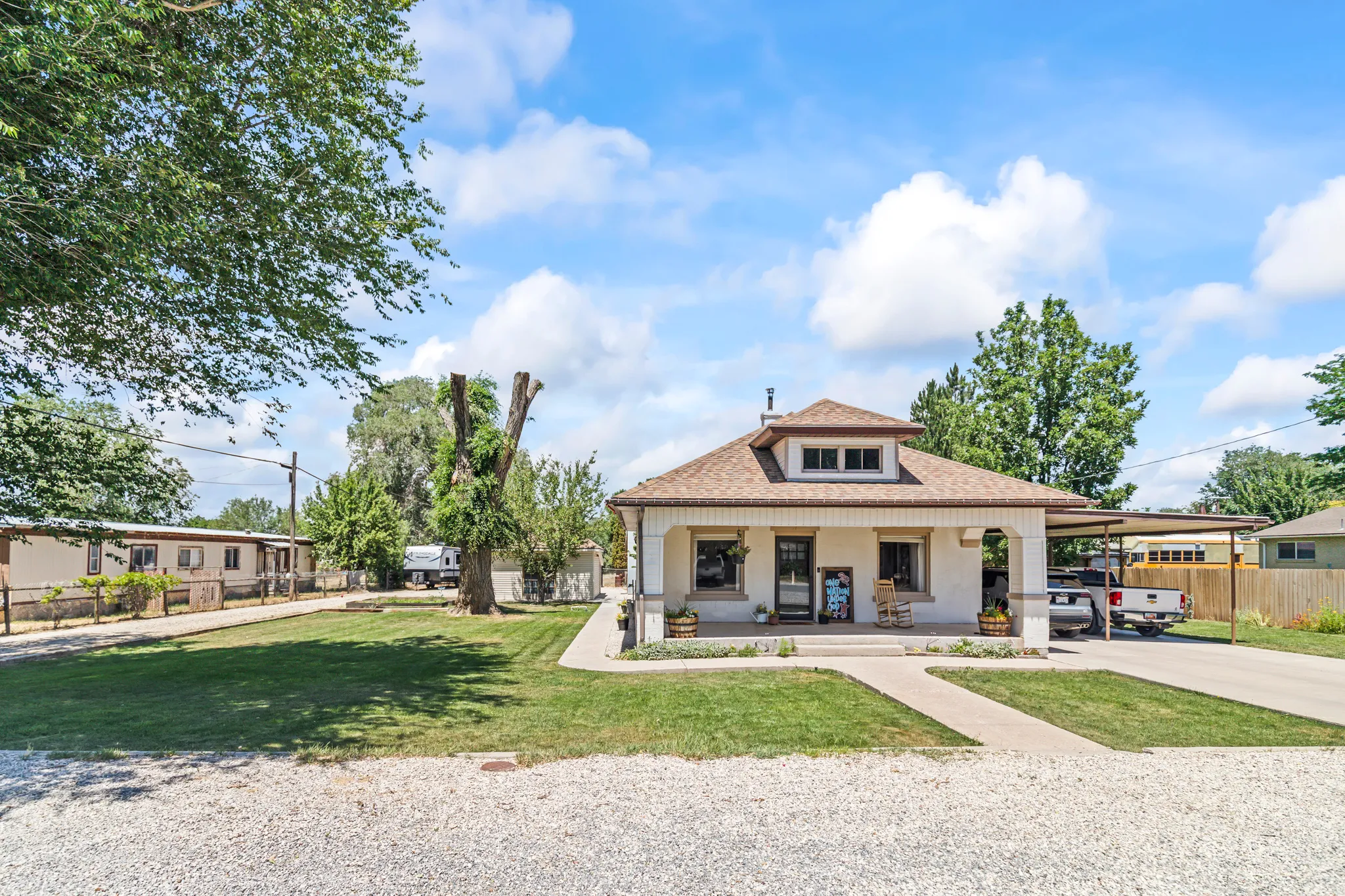 Single-story residence featuring a covered front porch, dormer window, and an attached carport