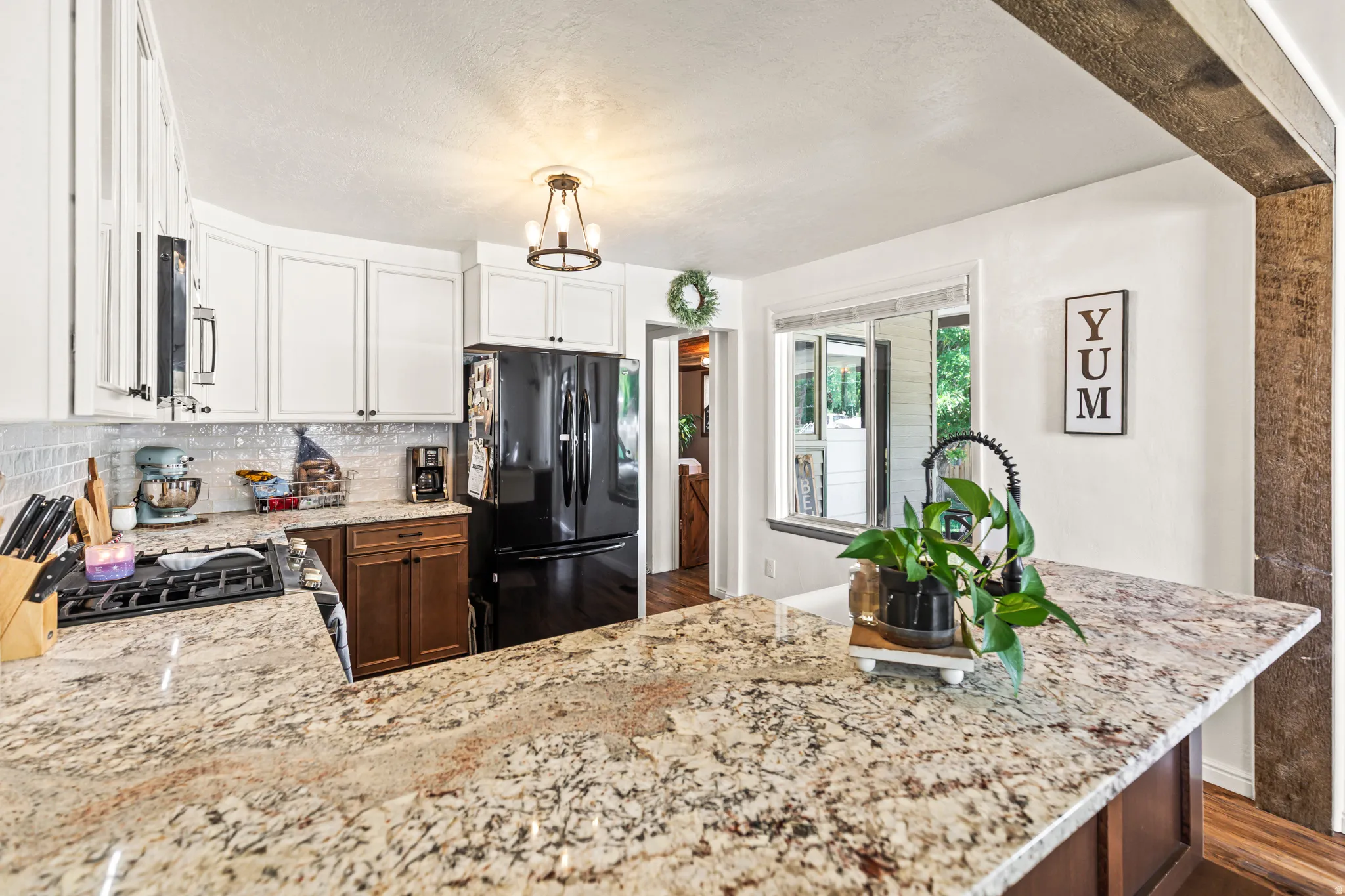Kitchen featuring granite countertops, a gas range, white upper cabinetry, and dark lower cabinetry
