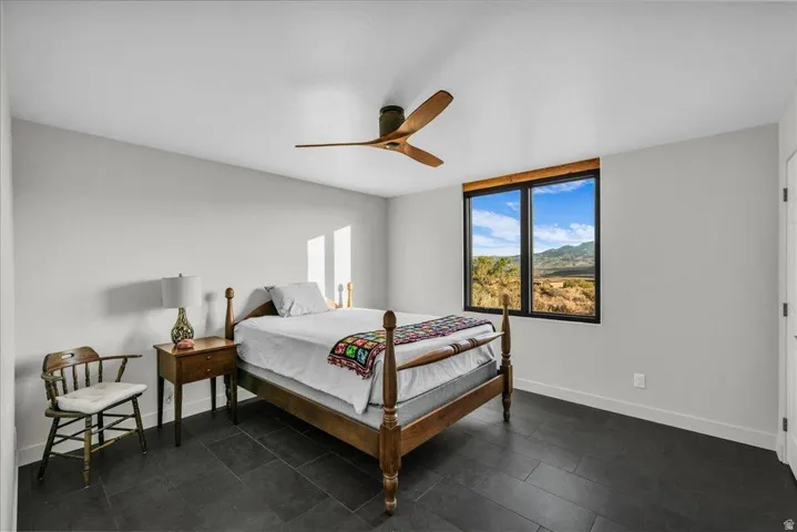 Spacious room featuring dark tile flooring and a ceiling fan