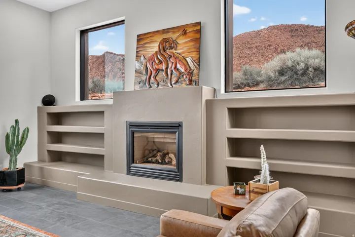 Built-in fireplace with a hearth, integrated shelving, and windows showcasing a mountain landscape