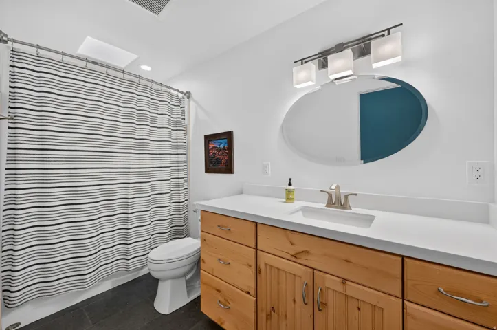 Wood-finish vanity with an integrated sink and light countertop