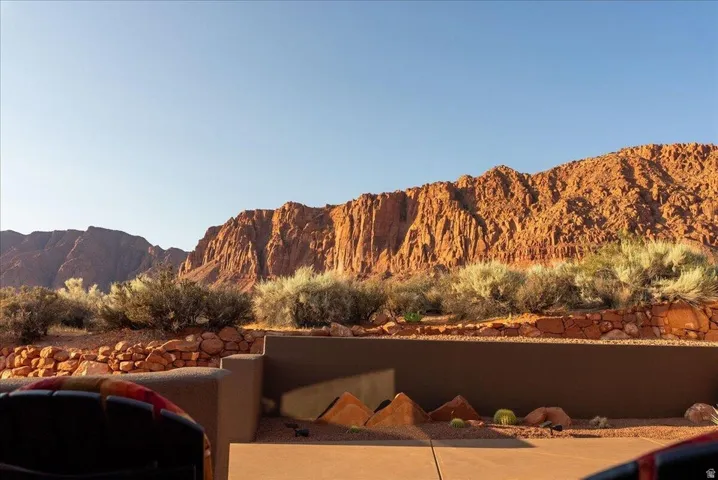 Expansive desert landscape featuring rugged red rock formations and natural shrubbery