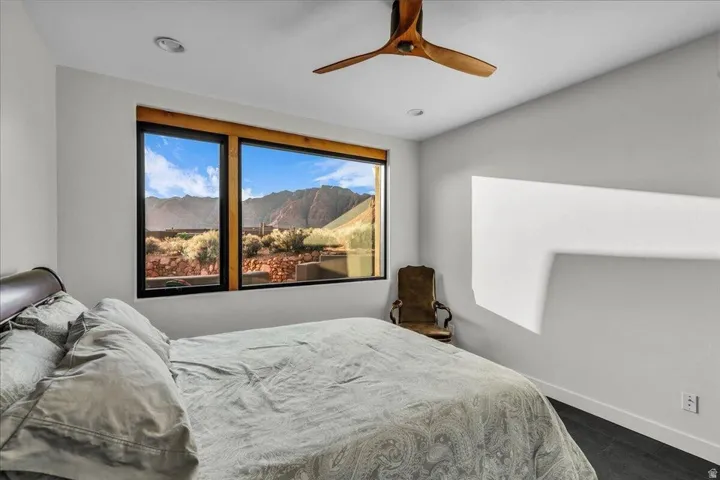 Expansive window with natural wood trim framing mountain and desert scenery