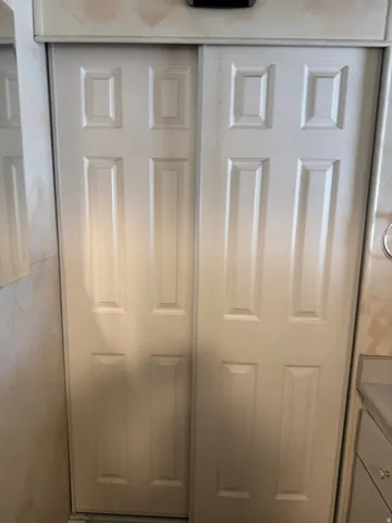 White bi-fold doors with recessed paneling and a painted finish