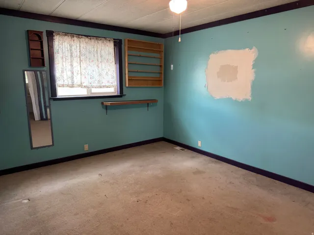 Room featuring a window, ceiling fan with light fixture, and wall-to-wall carpeting
