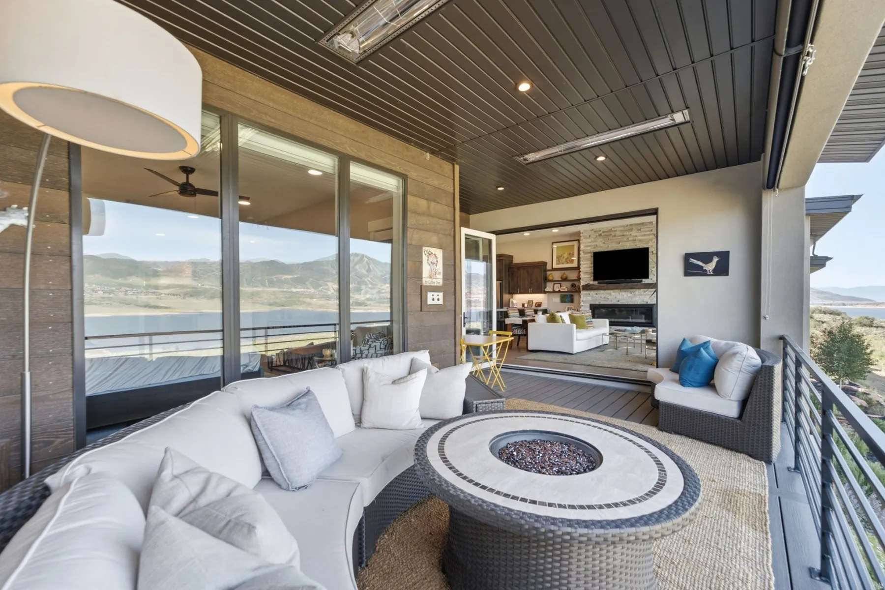 Expansive covered patio featuring a built-in fire pit, recessed lighting, and ceiling-mounted heaters