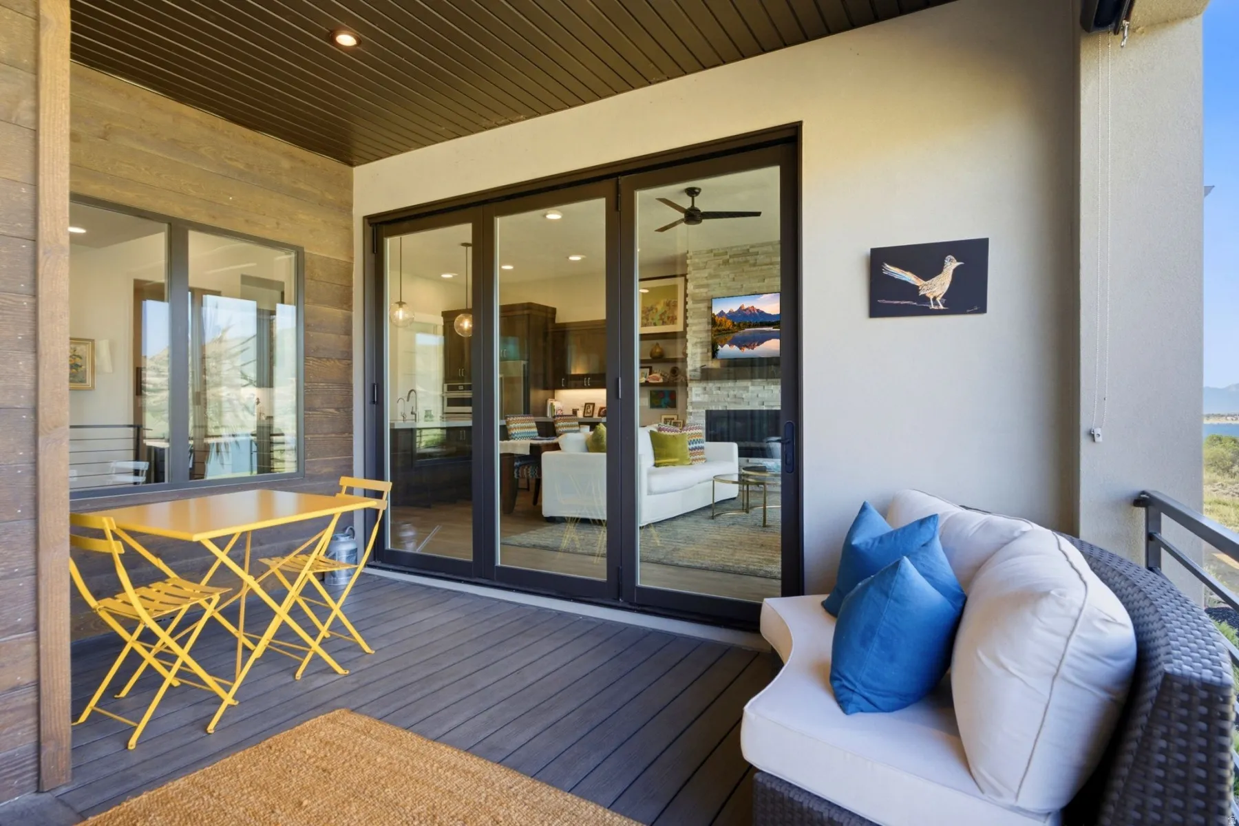 Covered outdoor patio featuring a slatted wood ceiling, durable decking, and a glass sliding door system
