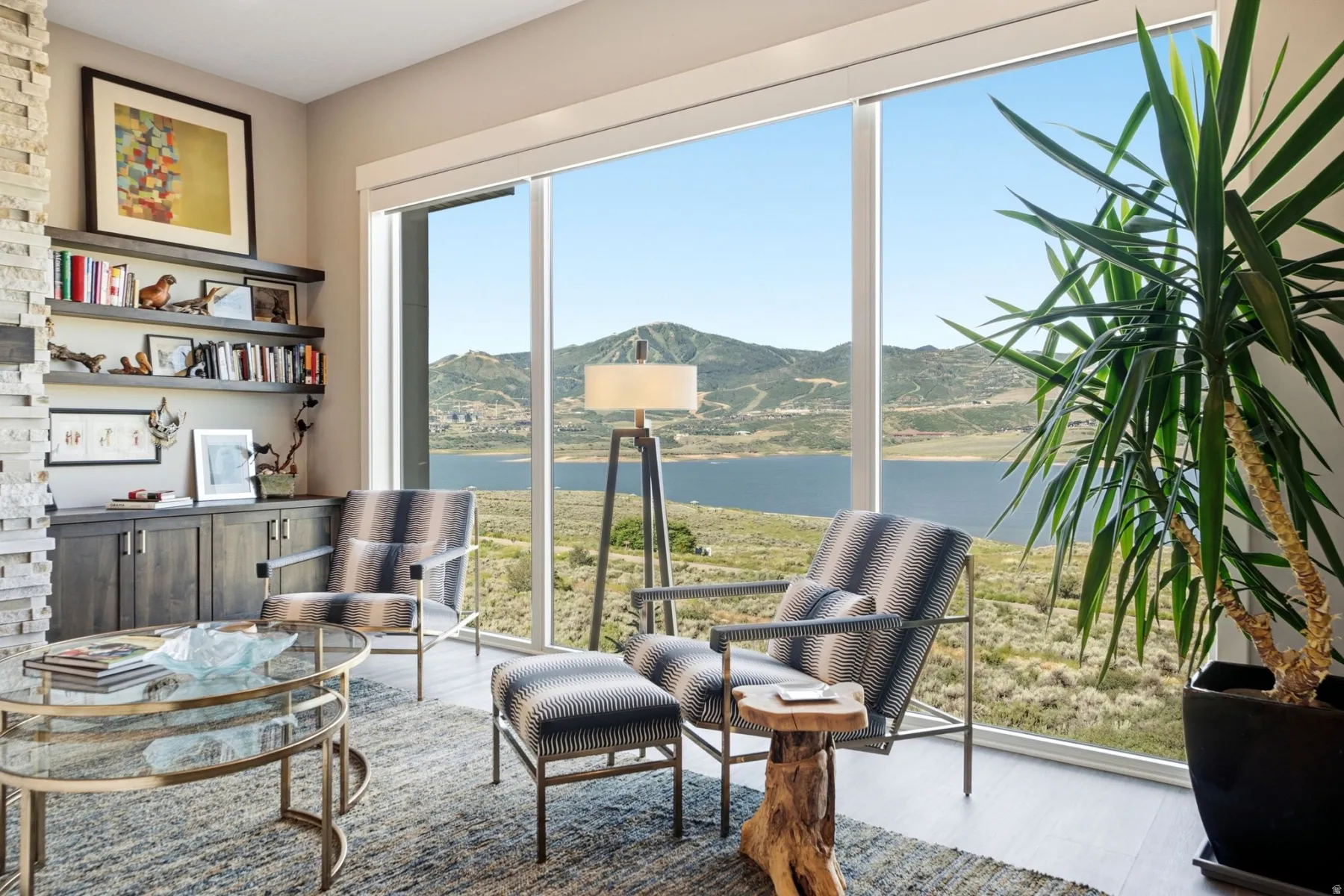Expansive floor-to-ceiling windows showcase mountain and lake scenery