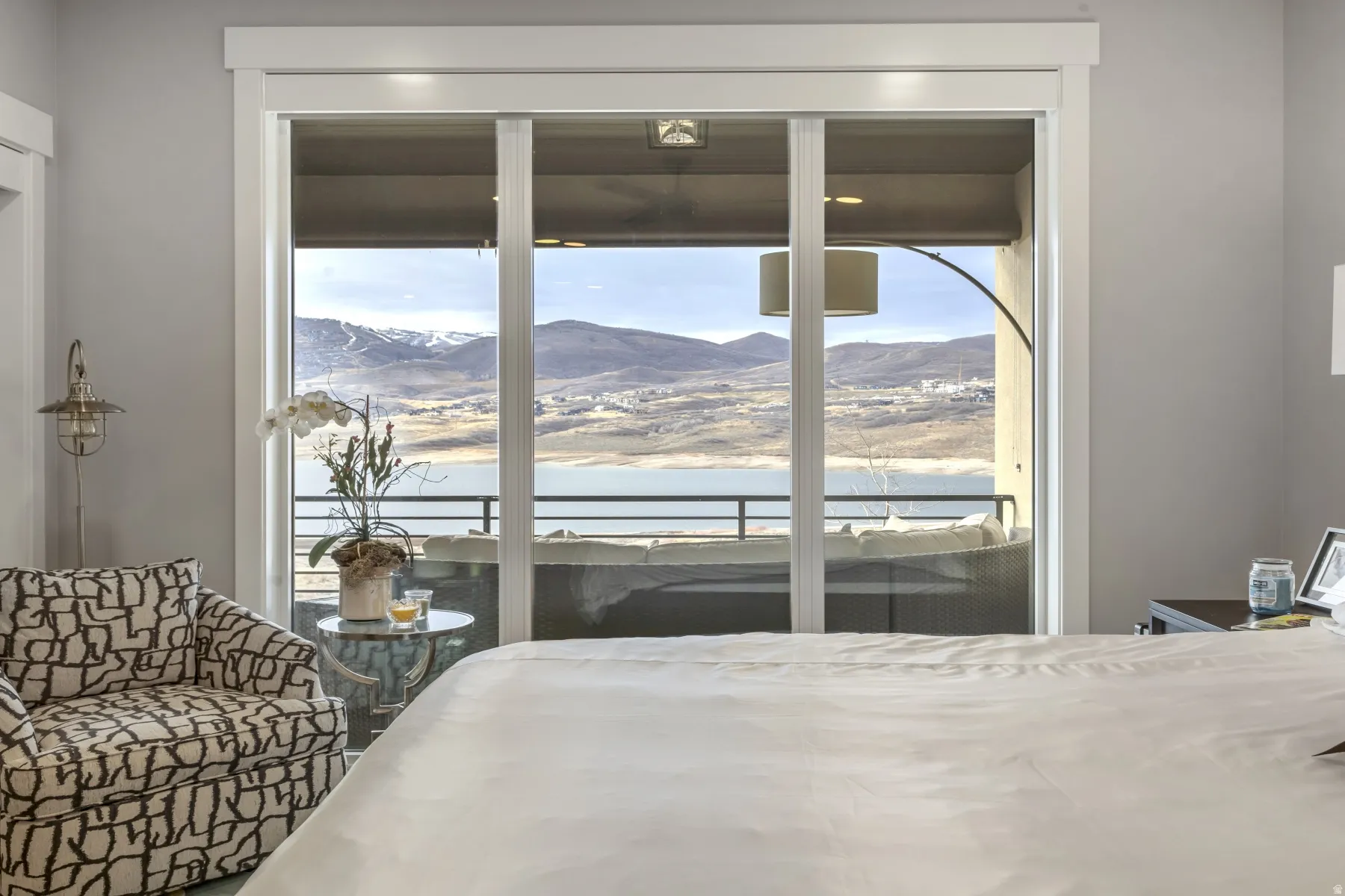 Sliding glass doors opening to a private balcony, offering expansive mountain and lake scenery