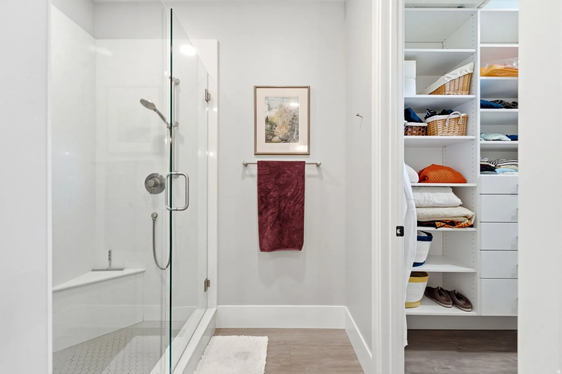 Glass-enclosed shower with a built-in bench, hexagon tile flooring, and brushed nickel fixtures
