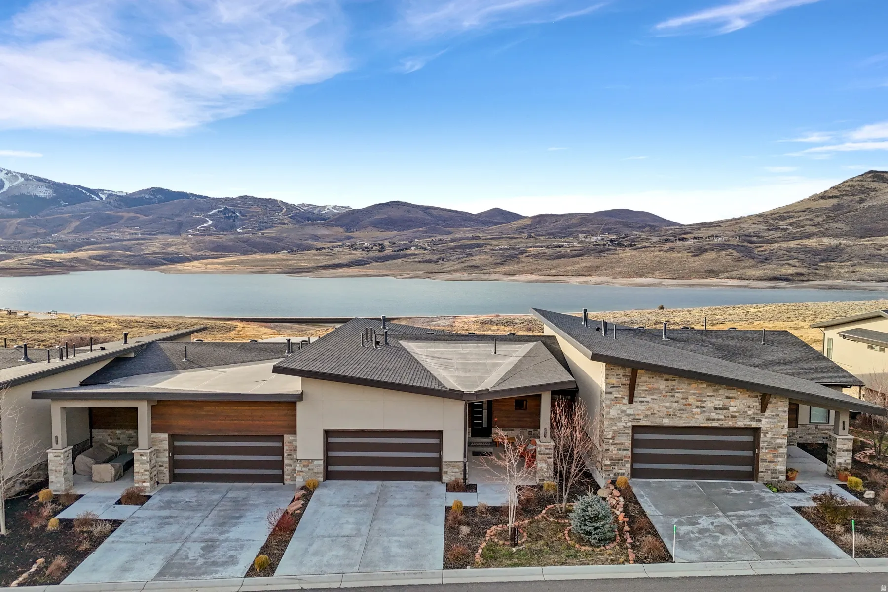 Modern architectural exterior featuring a blend of stone veneer and stucco finishes