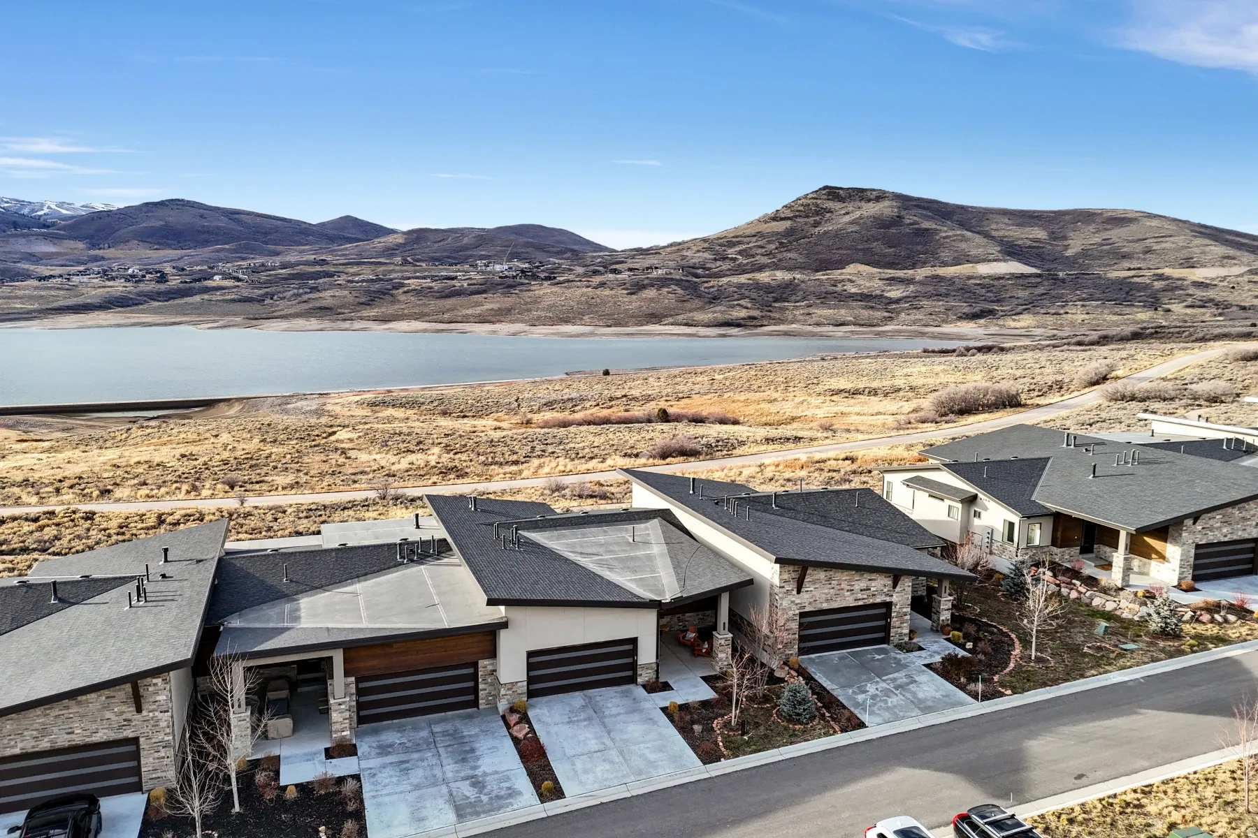 Modern architectural homes featuring dark roofing and stone accents