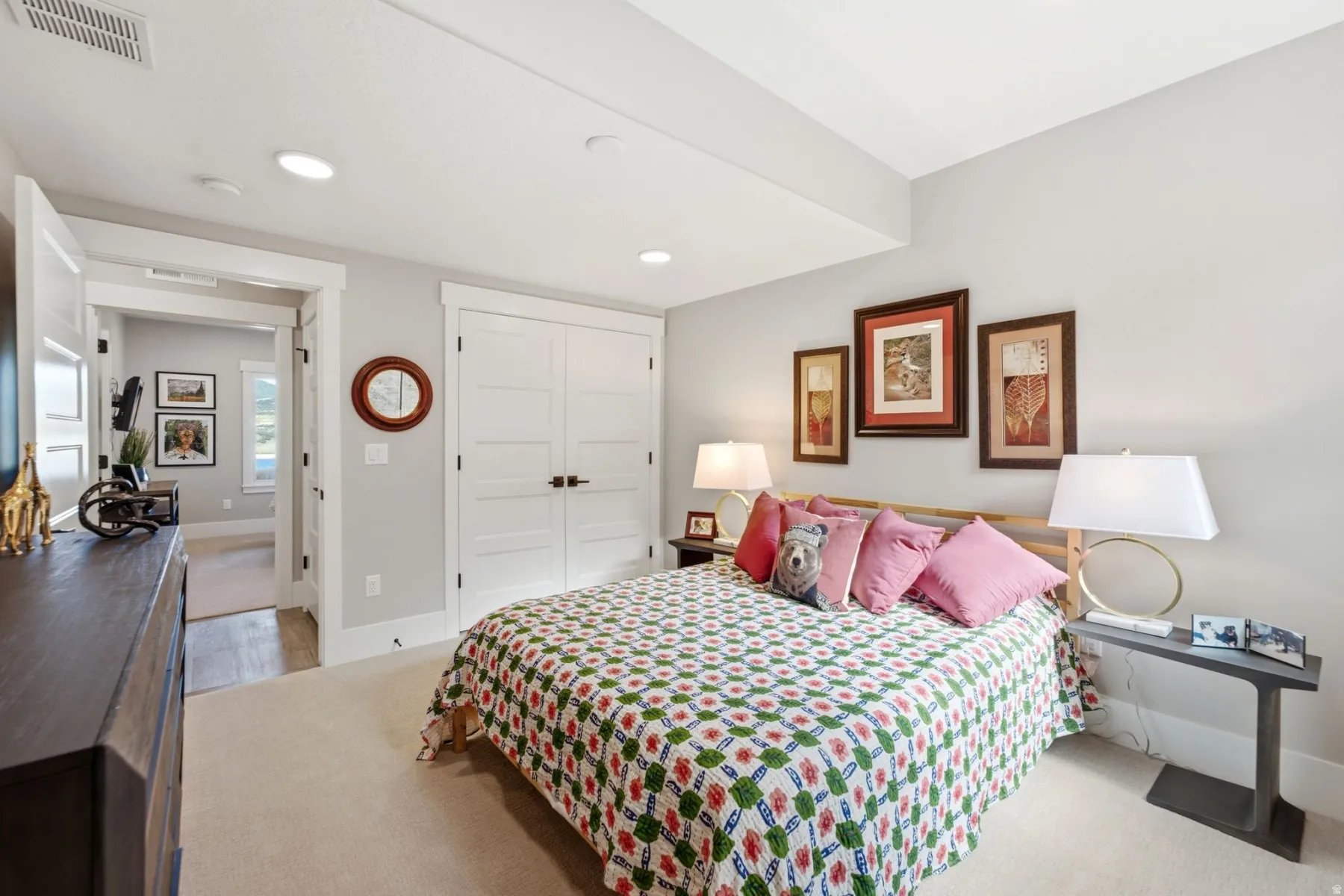 Carpeted room featuring a double-door closet with dark hardware, recessed lighting, and white baseboards