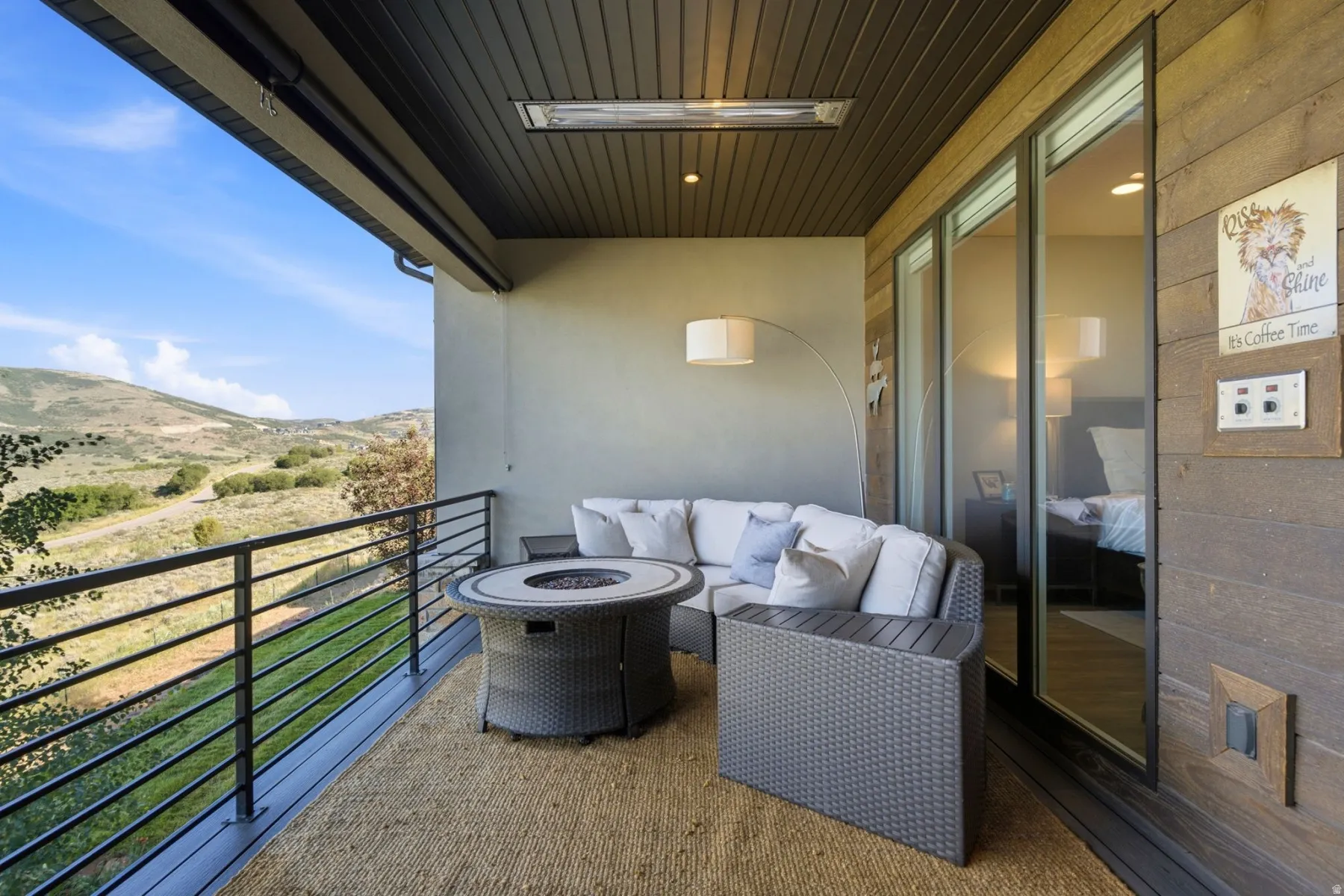 Covered exterior deck featuring a ceiling-mounted heater, dark wood plank ceiling, and a light-toned stucco wall