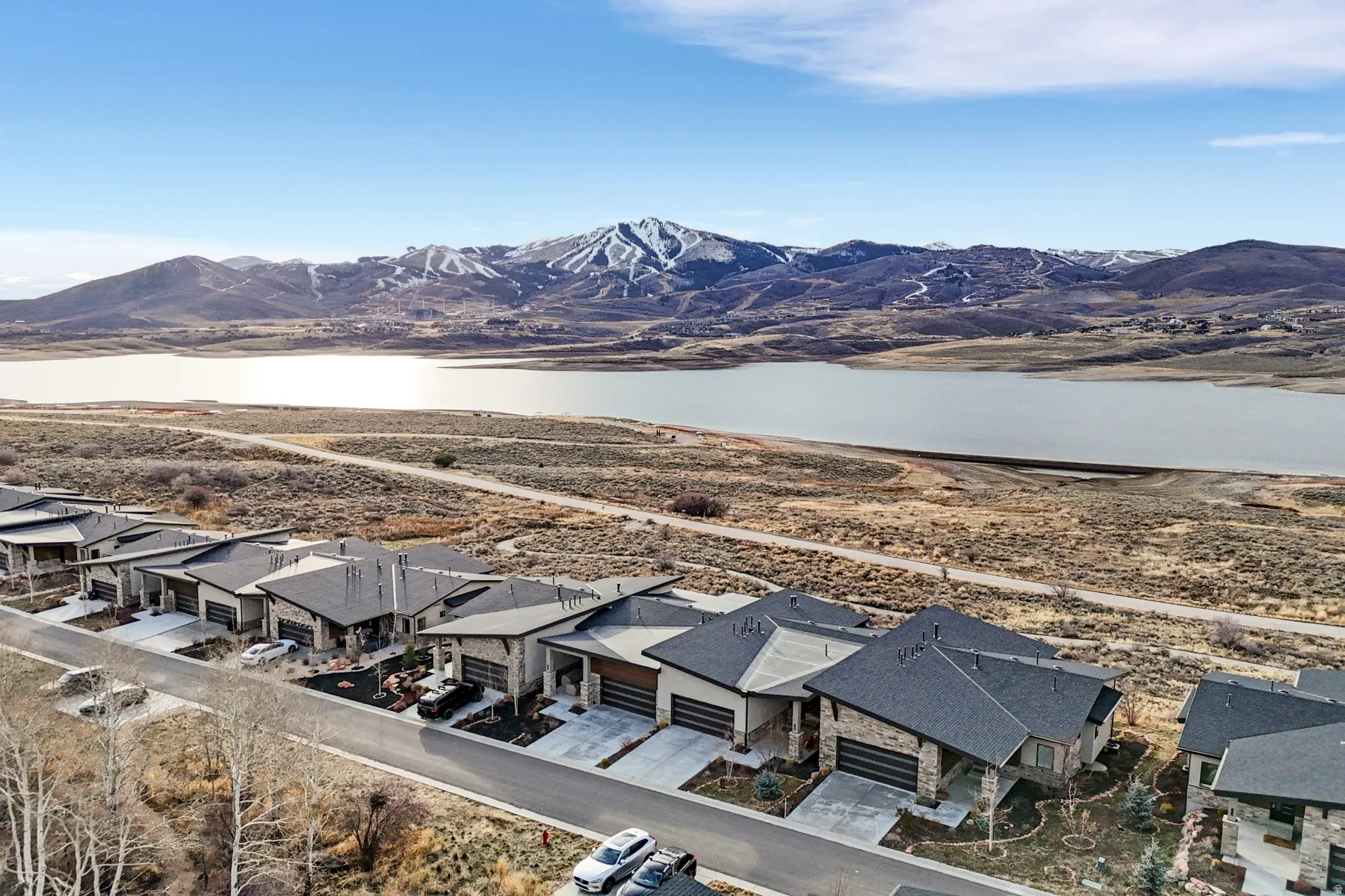 Modern residences with stone and stucco exteriors, shingle roofs, and attached garages