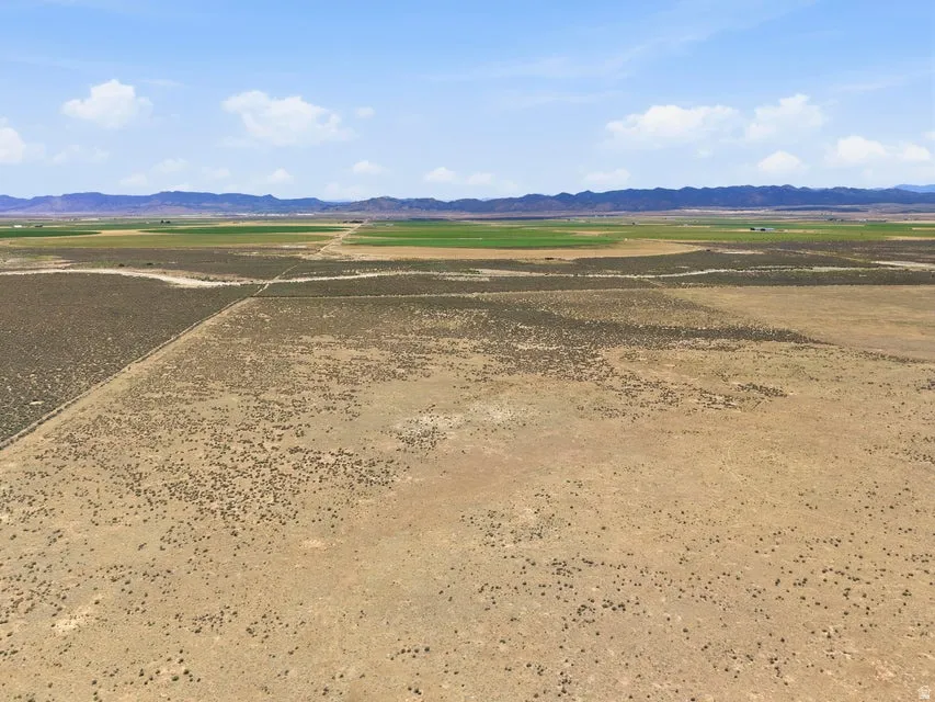 Expansive land parcel featuring arid terrain with scattered vegetation