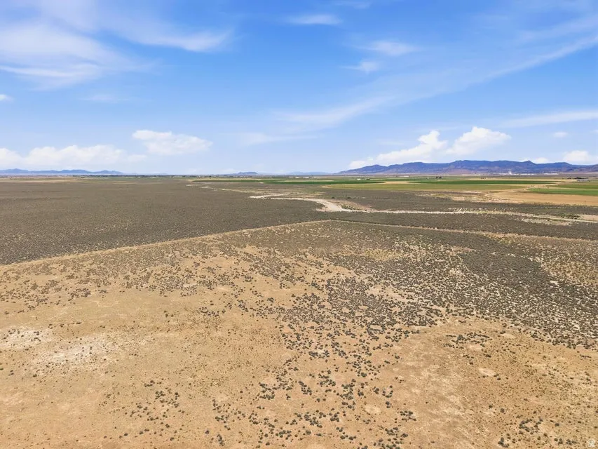Expansive undeveloped land featuring varied terrain and distant mountain ranges