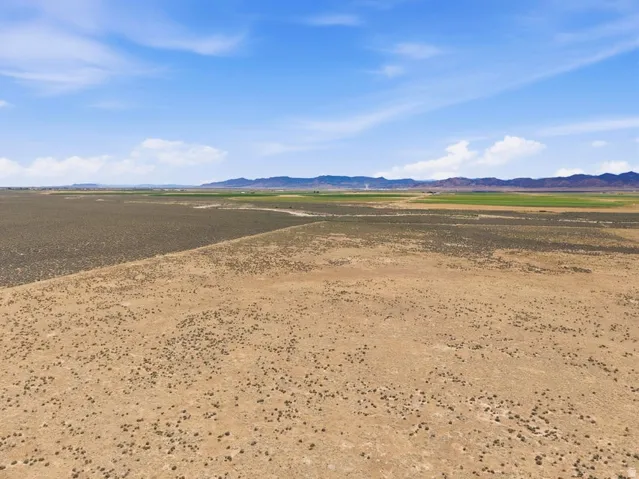 Expansive land parcel featuring arid terrain with scattered low-lying vegetation