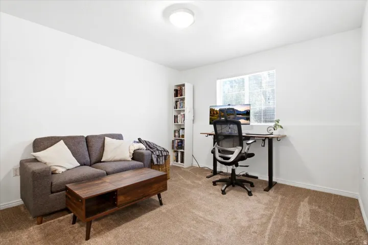 Carpeted room with white walls, a built-in window, and a flush-mount ceiling light fixture