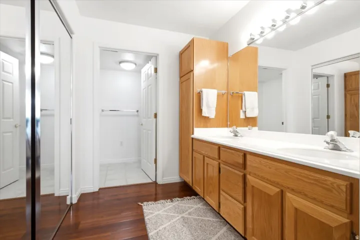Double vanity featuring light wood cabinetry and integrated sinks