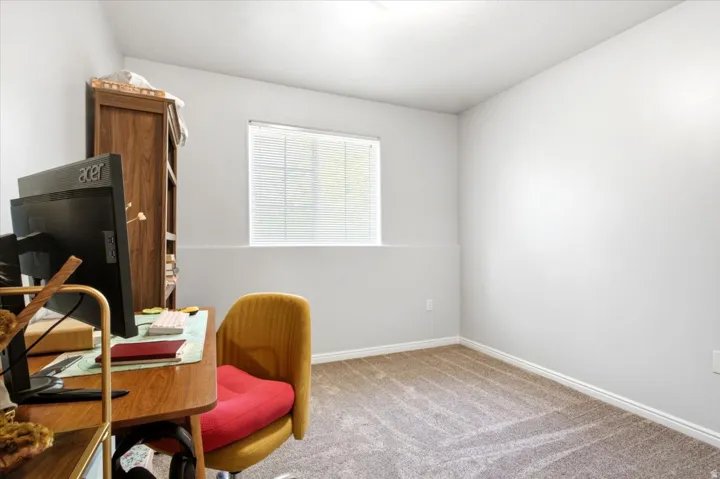Carpeted room featuring light gray walls, a window with horizontal blinds, and white trim