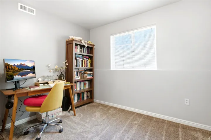 Carpeted room featuring a window with blinds, baseboards, and a ceiling air vent